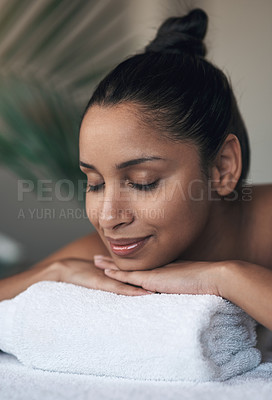 Buy stock photo Shot of a young woman lying on a massage bed at a spa