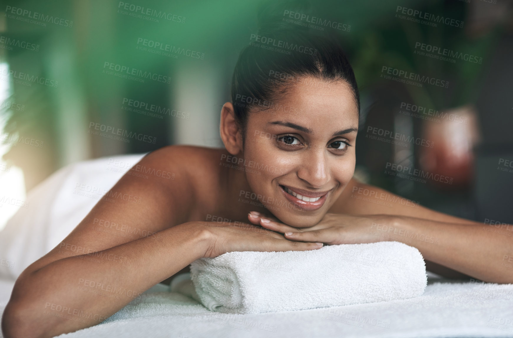 Buy stock photo Portrait of a young woman lying on a massage bed at a spa