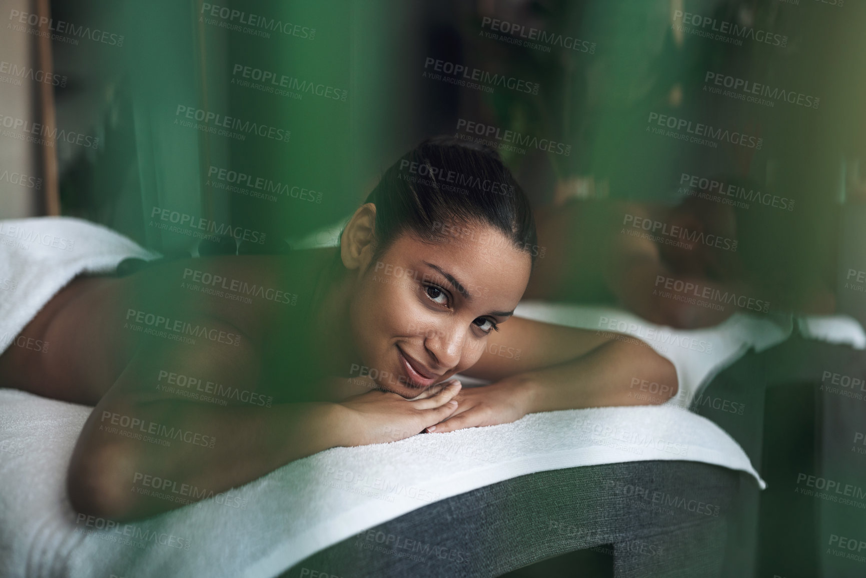 Buy stock photo Portrait of a young woman lying on a massage bed at a spa