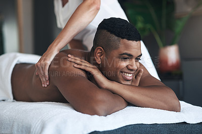 Buy stock photo Shot of a young man getting a back massage at a spa