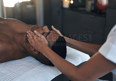 Buy stock photo Shot of a young man getting a face massage at a spa