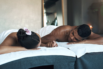 Buy stock photo Shot of a young couple relaxing on massage beds at a spa