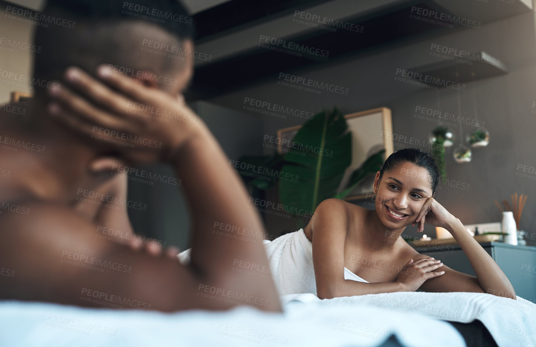 Buy stock photo Shot of a young couple relaxing on massage beds at a spa