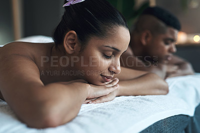 Buy stock photo Shot of a young woman lying on a massage bed with her partner at a spa
