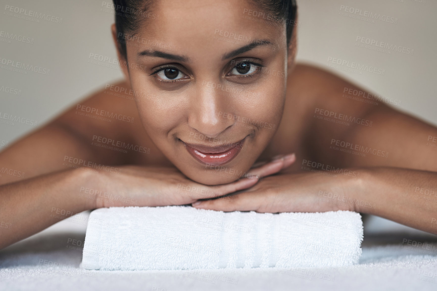 Buy stock photo Portrait of a young woman lying on a massage bed at a spa