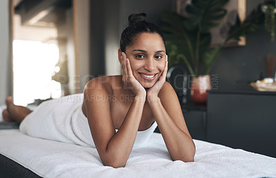 Buy stock photo Portrait of a young woman relaxing on a massage bed at a spa