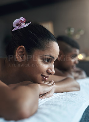 Buy stock photo Shot of a young woman lying on a massage bed with her partner at a spa