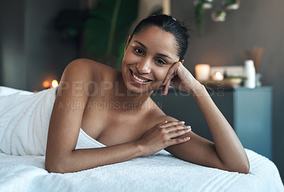 Buy stock photo Portrait of a young woman relaxing on a massage bed at a spa