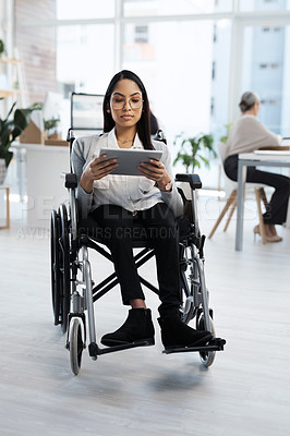 Buy stock photo Full length shot of an attractive young businesswoman in a wheelchair using her tablet in the office