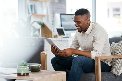 Buy stock photo Shot of a young businessman using a digital tablet in an office