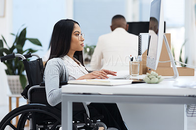 Buy stock photo Cropped shot of an attractive young businesswoman in a wheelchair working at her desk in the office