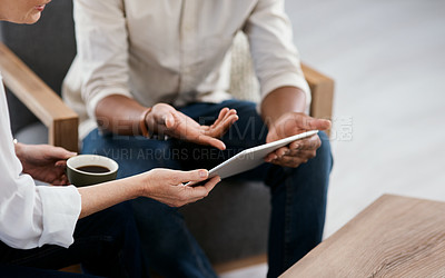 Buy stock photo Closeup shot of two unrecognisable businesspeople using a digital tablet together in an office
