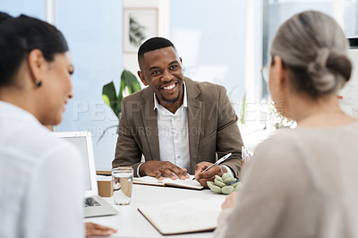 Buy stock photo Cropped shot of a handsome young businessman meeting with two female colleagues in the office