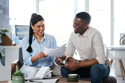 Buy stock photo Shot of two businesspeople going through paperwork together in an office