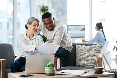 Buy stock photo Shot of two businesspeople going through paperwork together in an office