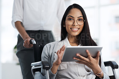 Buy stock photo Cropped portrait of an attractive young businesswoman in a wheelchair using her tablet in the office