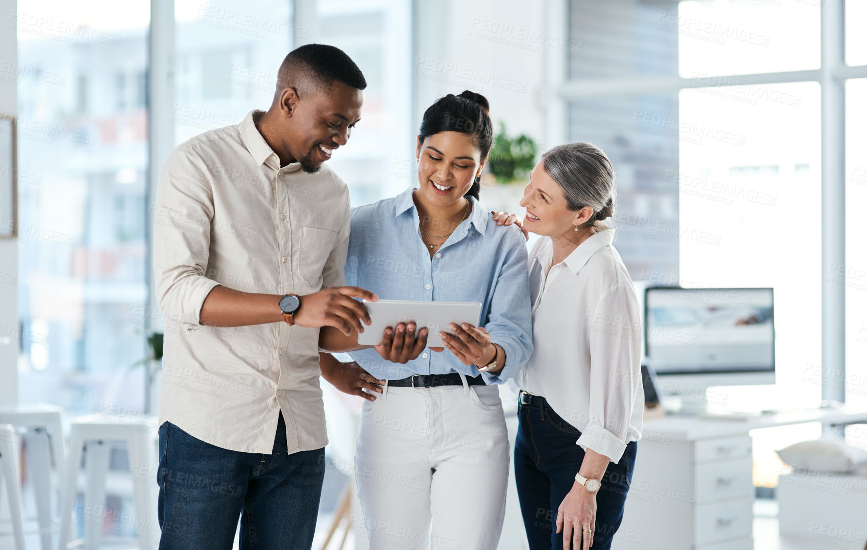 Buy stock photo Shot of a group of businesspeople using a digital tablet together in an office