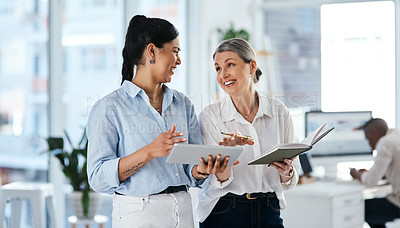 Buy stock photo Shot of two businesswomen using a digital tablet together in an office