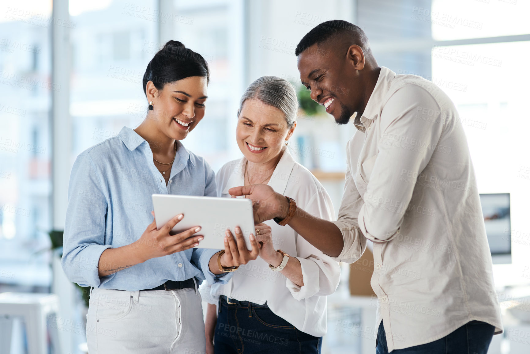 Buy stock photo Shot of a group of businesspeople using a digital tablet together in an office