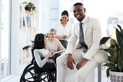 Buy stock photo Cropped portrait of a handsome young businessman in the office with his colleagues meeting in the background