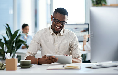 Buy stock photo Shot of a young businessman using a digital tablet in an office