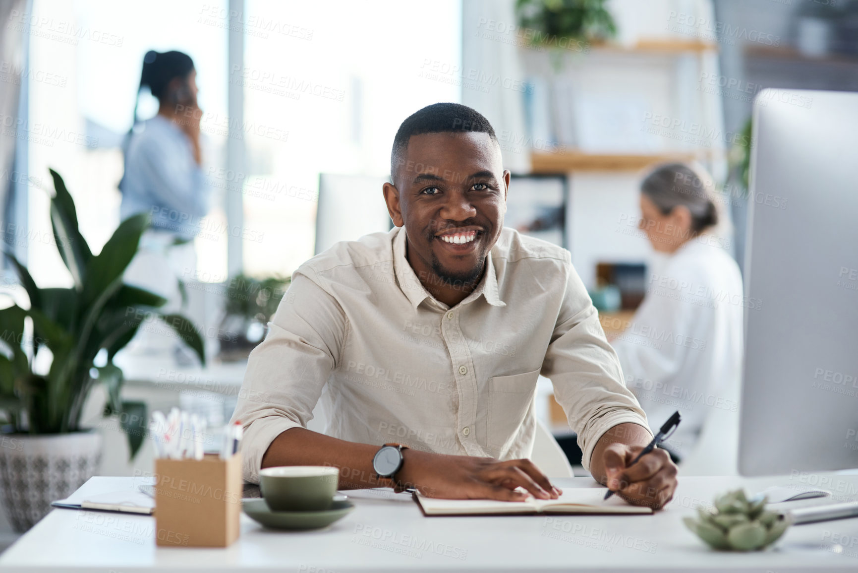 Buy stock photo Portrait of a young businessman writing notes in an office