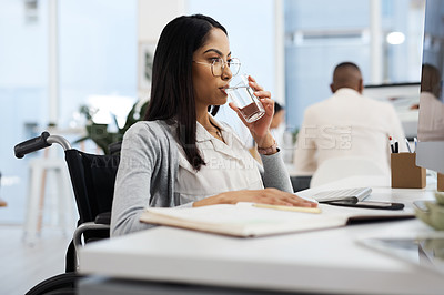 Buy stock photo Cropped shot of an attractive young businesswoman drinking water while working at her desk in the office