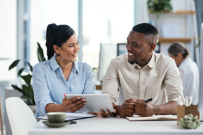 Buy stock photo Shot of two businesspeople using a digital tablet together in an office