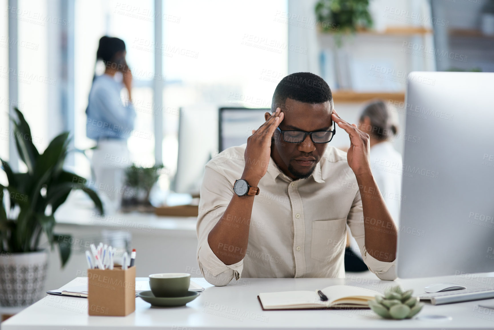 Buy stock photo Shot of a young businessman looking stressed out while working in an office