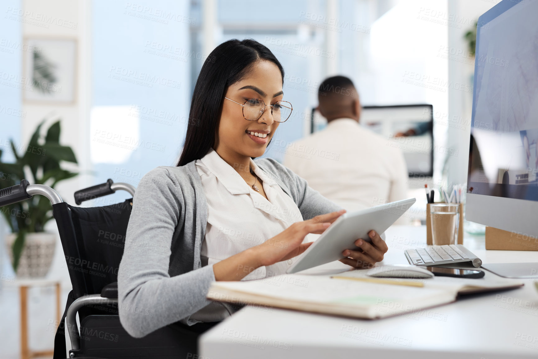 Buy stock photo Cropped shot of an attractive young businesswoman working on a tablet at her desk in the office