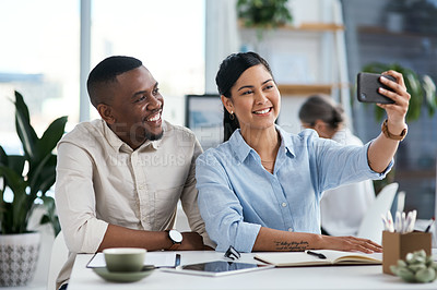 Buy stock photo Shot of two businesspeople taking selfies together in an office