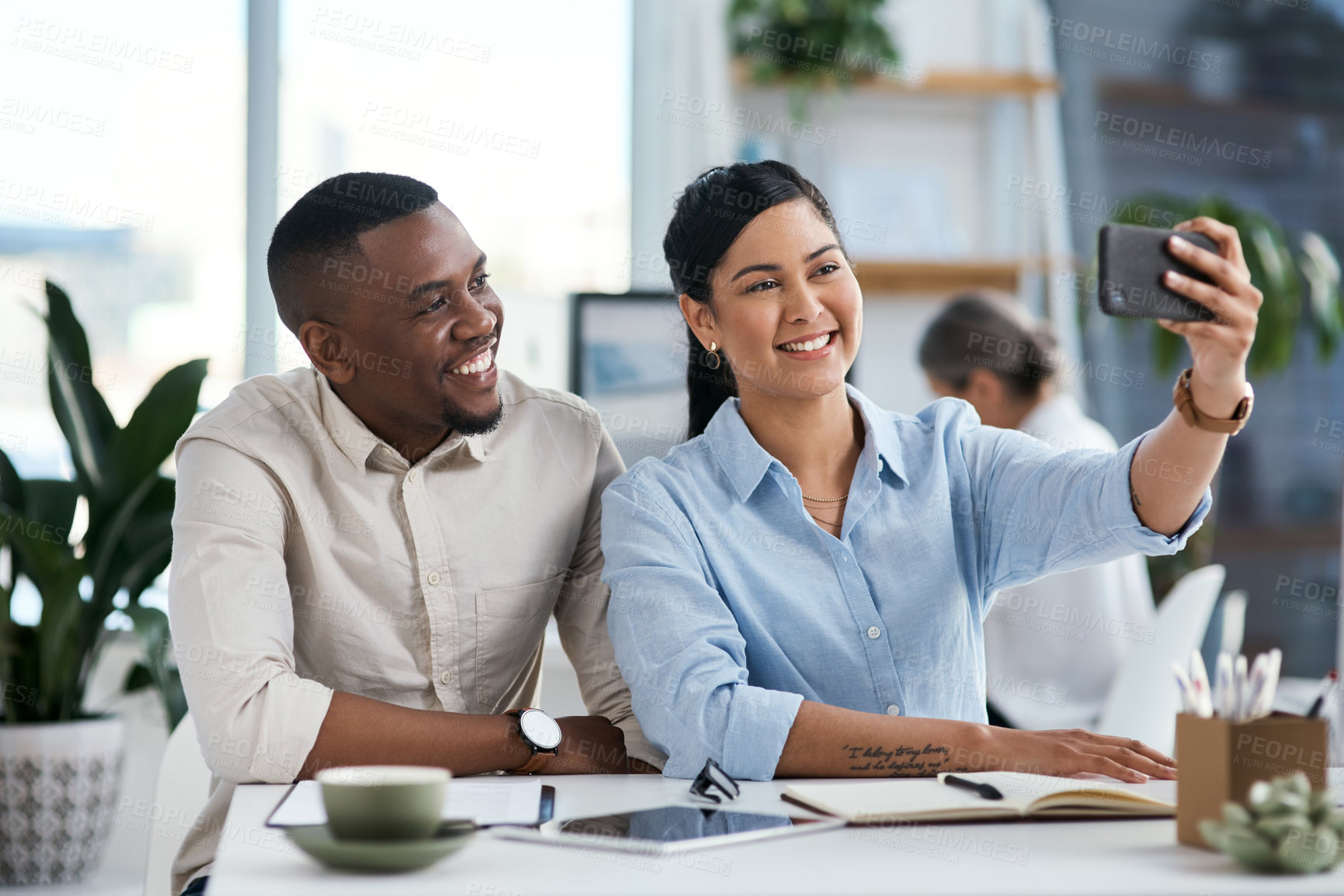 Buy stock photo Shot of two businesspeople taking selfies together in an office