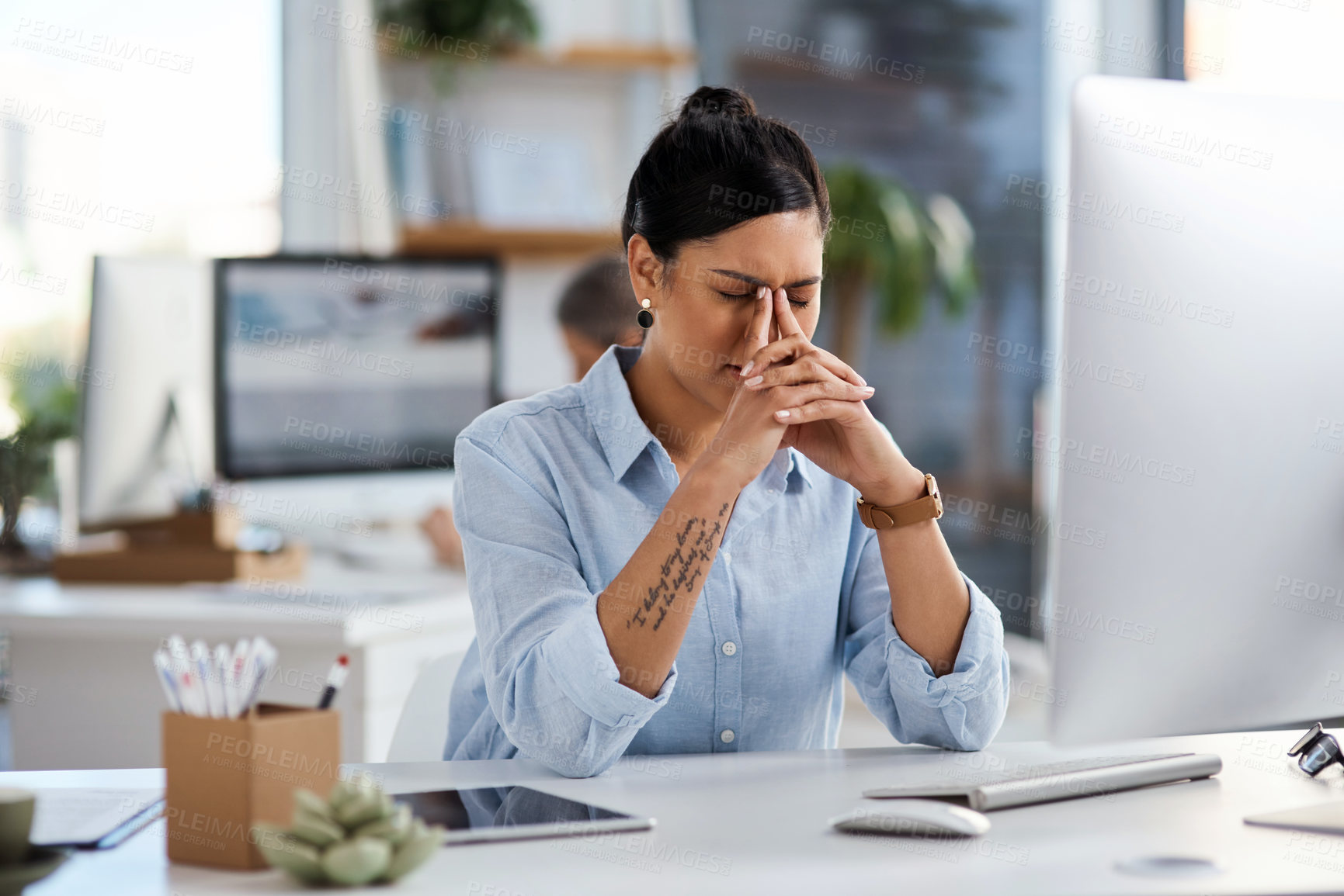 Buy stock photo Shot of a young businesswoman looking stressed out while working in an office