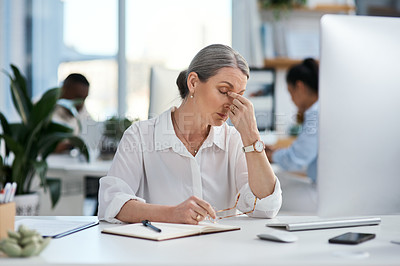 Buy stock photo Shot of a mature businesswoman looking stressed out while working in an office