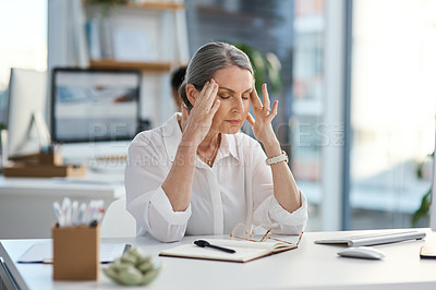 Buy stock photo Shot of a mature businesswoman looking stressed out while working in an office