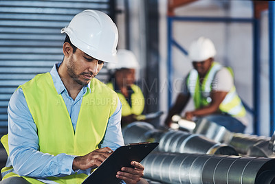 Buy stock photo Shot of a handsome young contractor crouching down and doing a stock-take in the warehouse