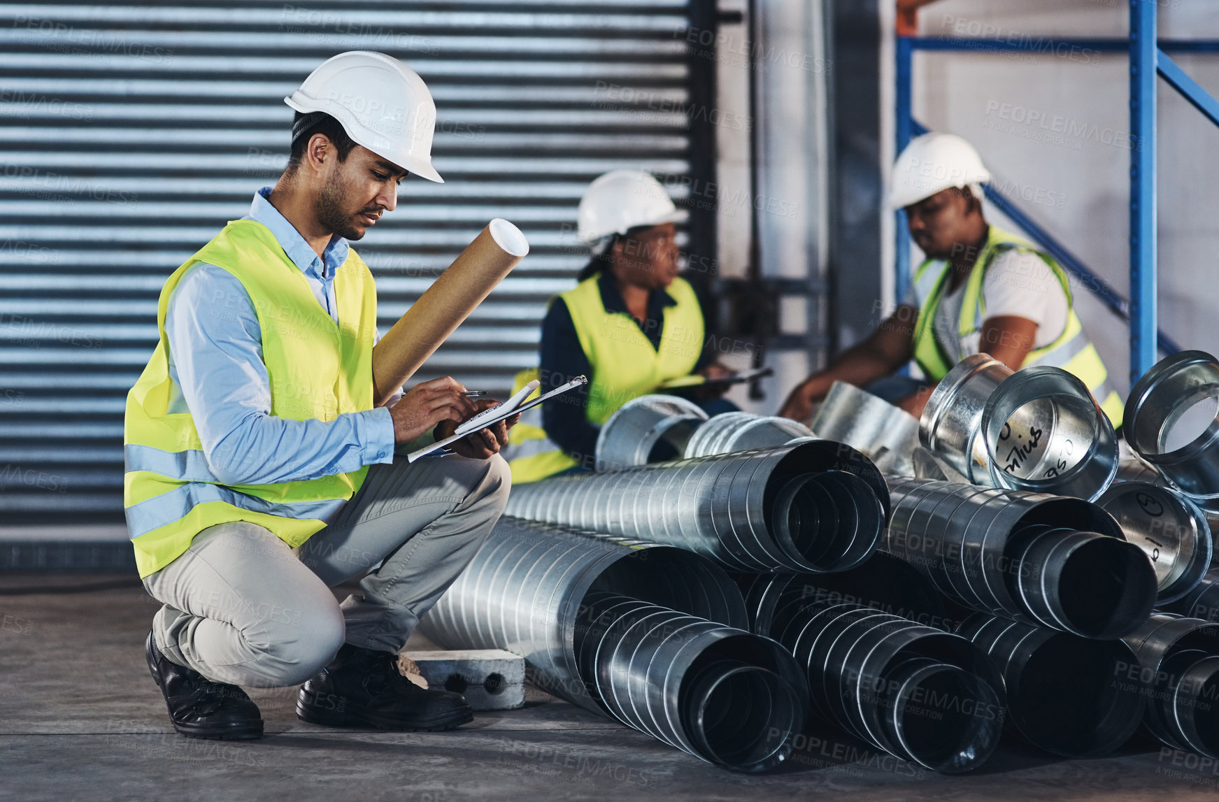 Buy stock photo Shot of a handsome young contractor crouching down and doing a stock-take in the warehouse