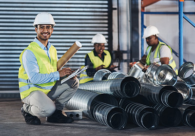 Buy stock photo Shot of a handsome young contractor crouching down and doing a stock-take in the warehouse