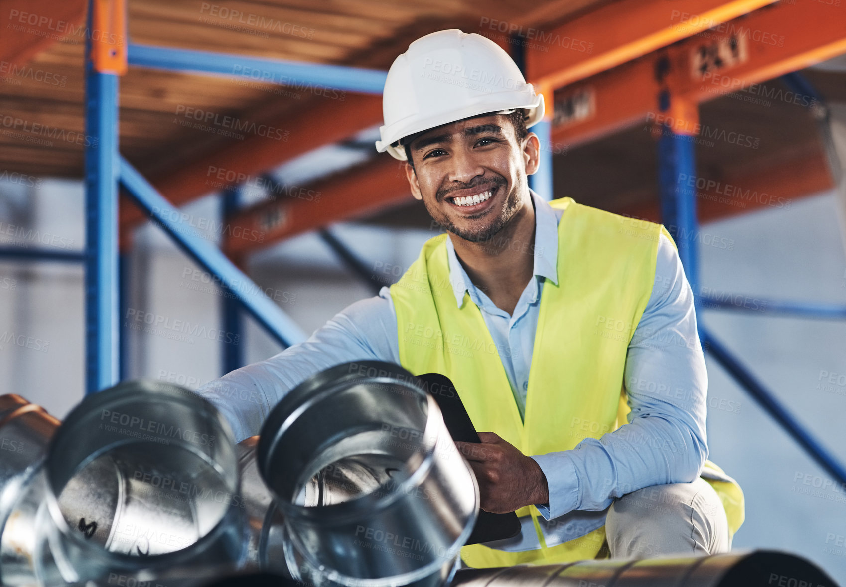 Buy stock photo Shot of a handsome young contractor crouching down and doing a stock-take in the warehouse