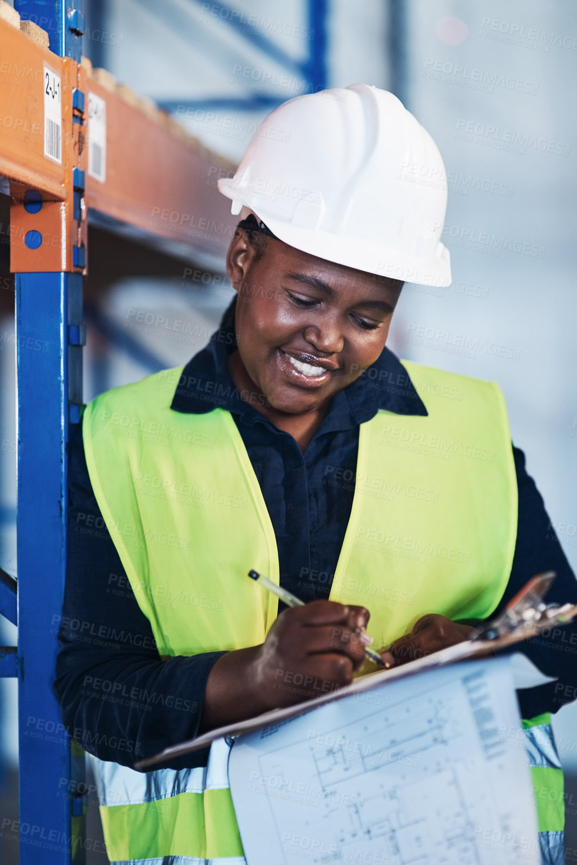 Buy stock photo Shot of an attractive young contractor standing in the warehouse and holding a clipboard