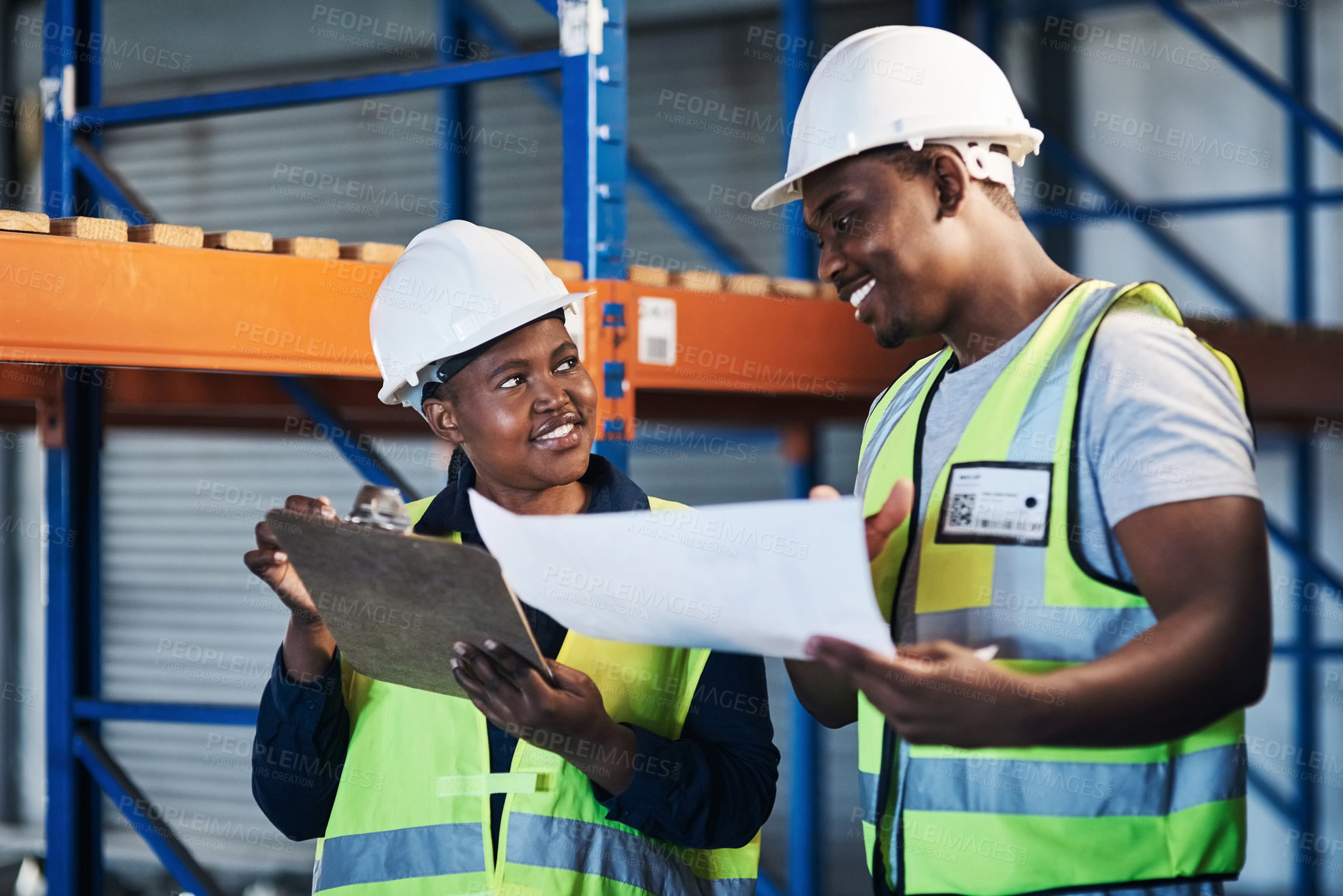 Buy stock photo Shot of two young contractors standing in the warehouse and having a discussion while doing a stock-take