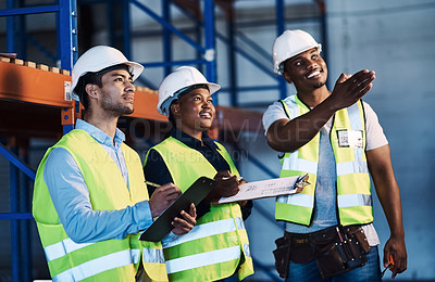 Buy stock photo Shot of a group of contractors standing in the warehouse and looking contemplative while having a discussion