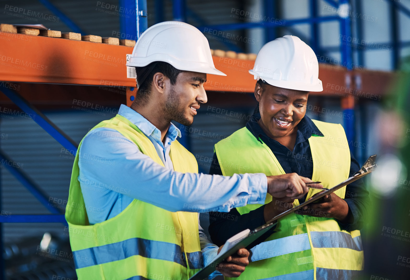 Buy stock photo Shot of two young contractors standing in the warehouse and having a discussion while doing a stock-take