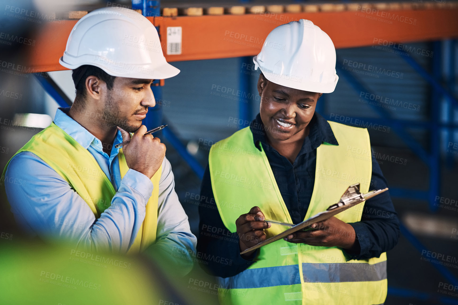 Buy stock photo Shot of two young contractors standing in the warehouse and having a discussion while doing a stock-take