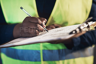 Buy stock photo Cropped shot of an unrecognizable contractor standing alone in the warehouse and writing on a document during stock-take