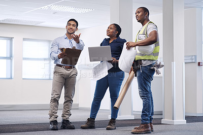 Buy stock photo Shot of a group of architects standing together and having a discussion about the room before they renovate