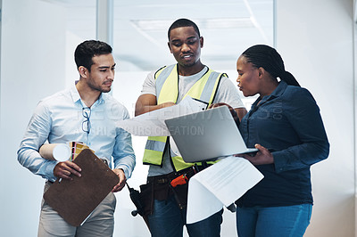 Buy stock photo Shot of a group of architects standing together and having a discussion about the room before they renovate