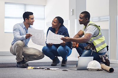 Buy stock photo Shot of a group of architects having a discussion about the floor plan before they renovate