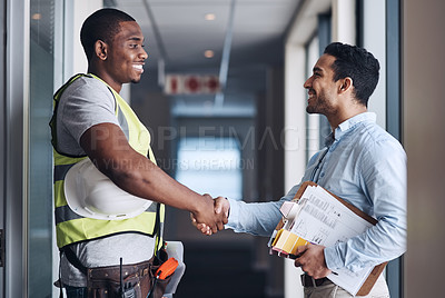 Buy stock photo Shot of two young architects standing together and shaking hands after a discussion about the room before they renovate