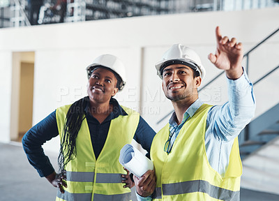 Buy stock photo Shot of two young contractors standing together in the warehouse and observing the layout